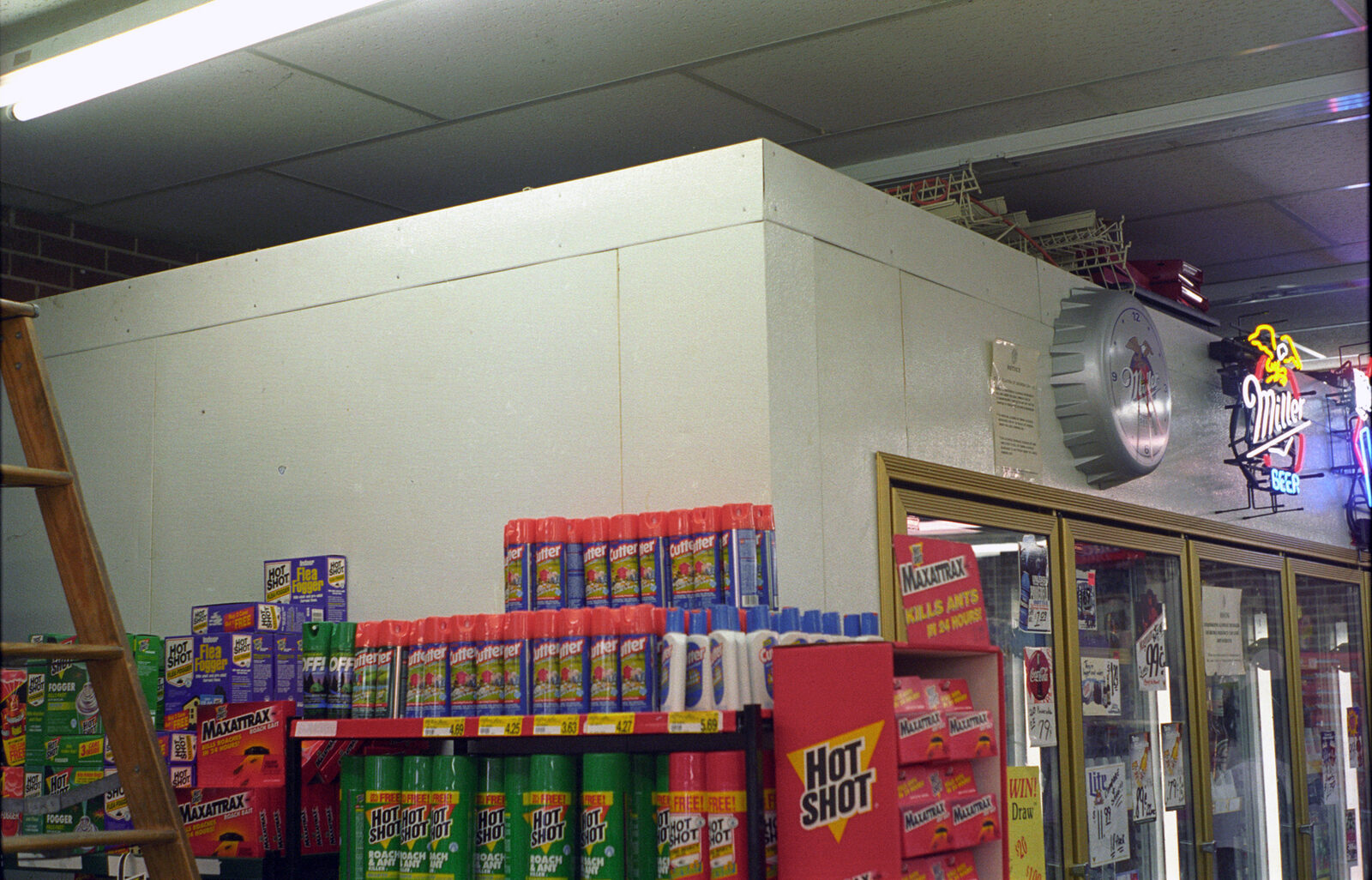 Walk-in cooler inside the store, with beer signs and cooler doors along the right wall