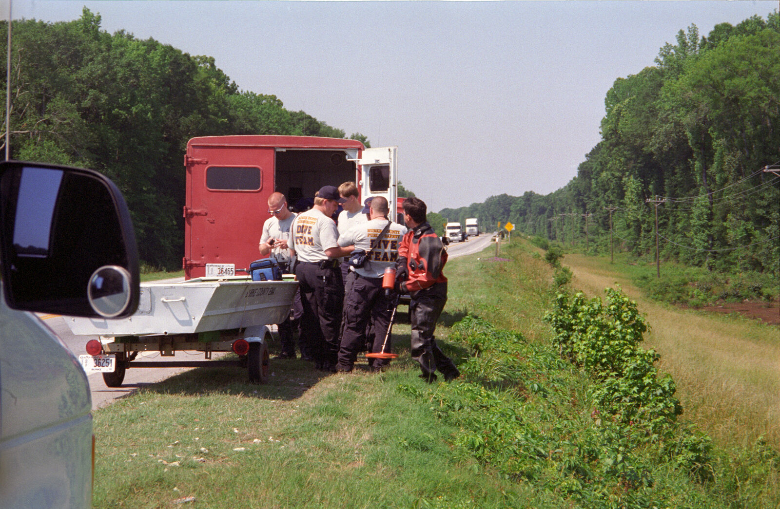 Burke County Public Safety dive team gathered beside their boat and trailer along the highway