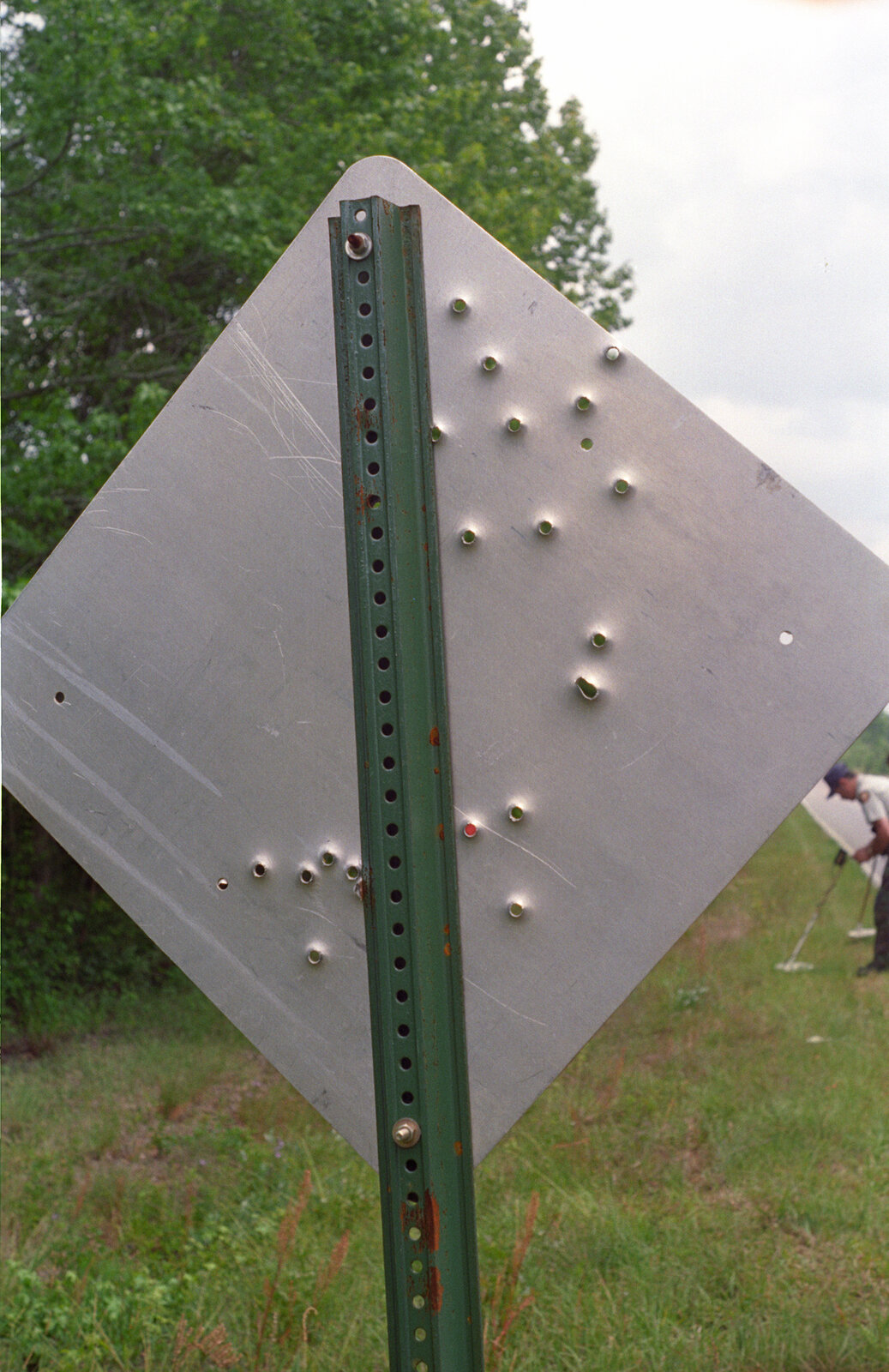 Back of a road sign with bullet holes along U.S. Highway 25